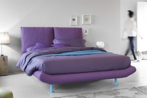 Letto matrimoniale con contenitore Secret Box a scomparsa. E' un letto innovativo che associa il piedino alto al contenitore. Molteplici sono le possibilità di personalizzarlo, sia nella scelta del rivestimento, sia nella scelta del colore dei piedini e della barra di testata.